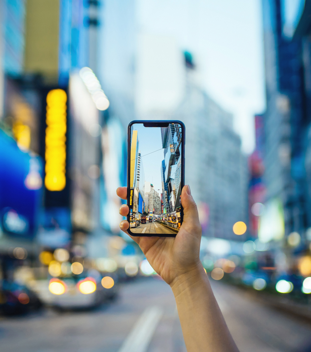 Person taking a picture of Causeway Bay with iPhone